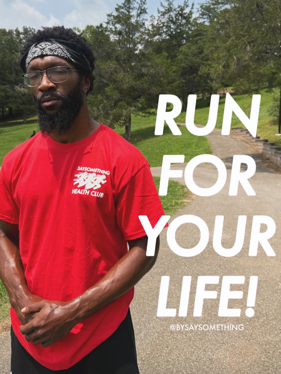 A man wearing a red t-shirt and black shorts stands outdoors on a path with trees in the background. Large white text on the right reads 'RUN FOR YOUR LIFE!' with a small hashtag below.